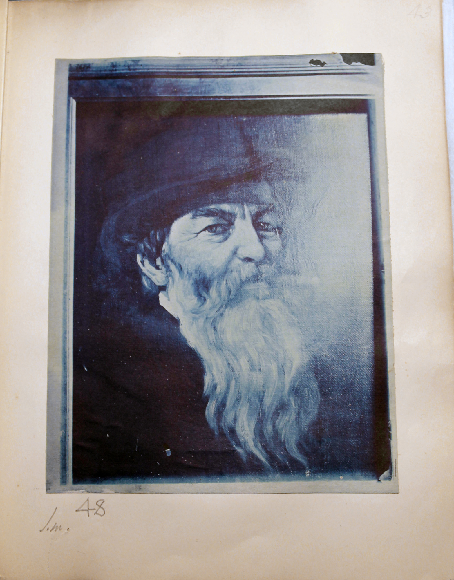 Blue toned photo of  painting of old man with long white beard smoking.