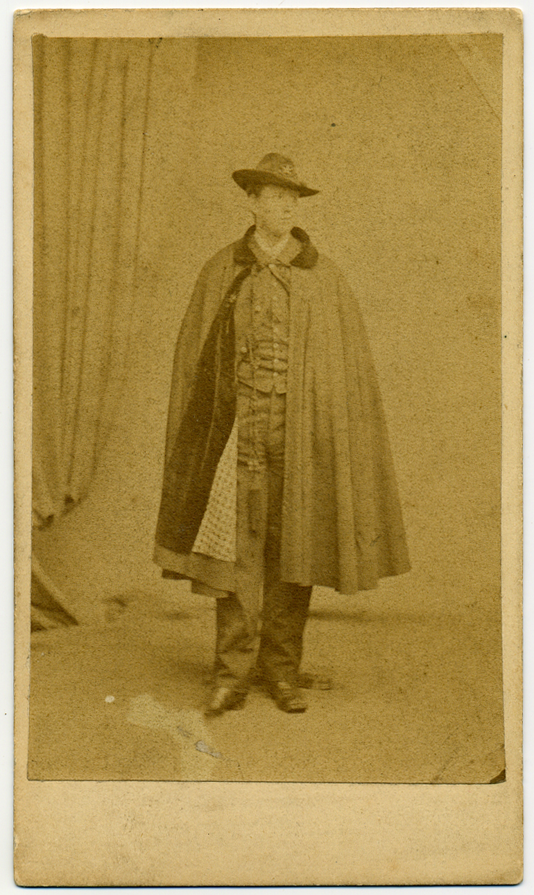 Portrait of young man in army uniform with cape.