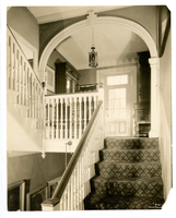 Black and white photograph of door at top of stairs.
