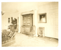 Black and white photograph of large 19th century library with dark furnishings.