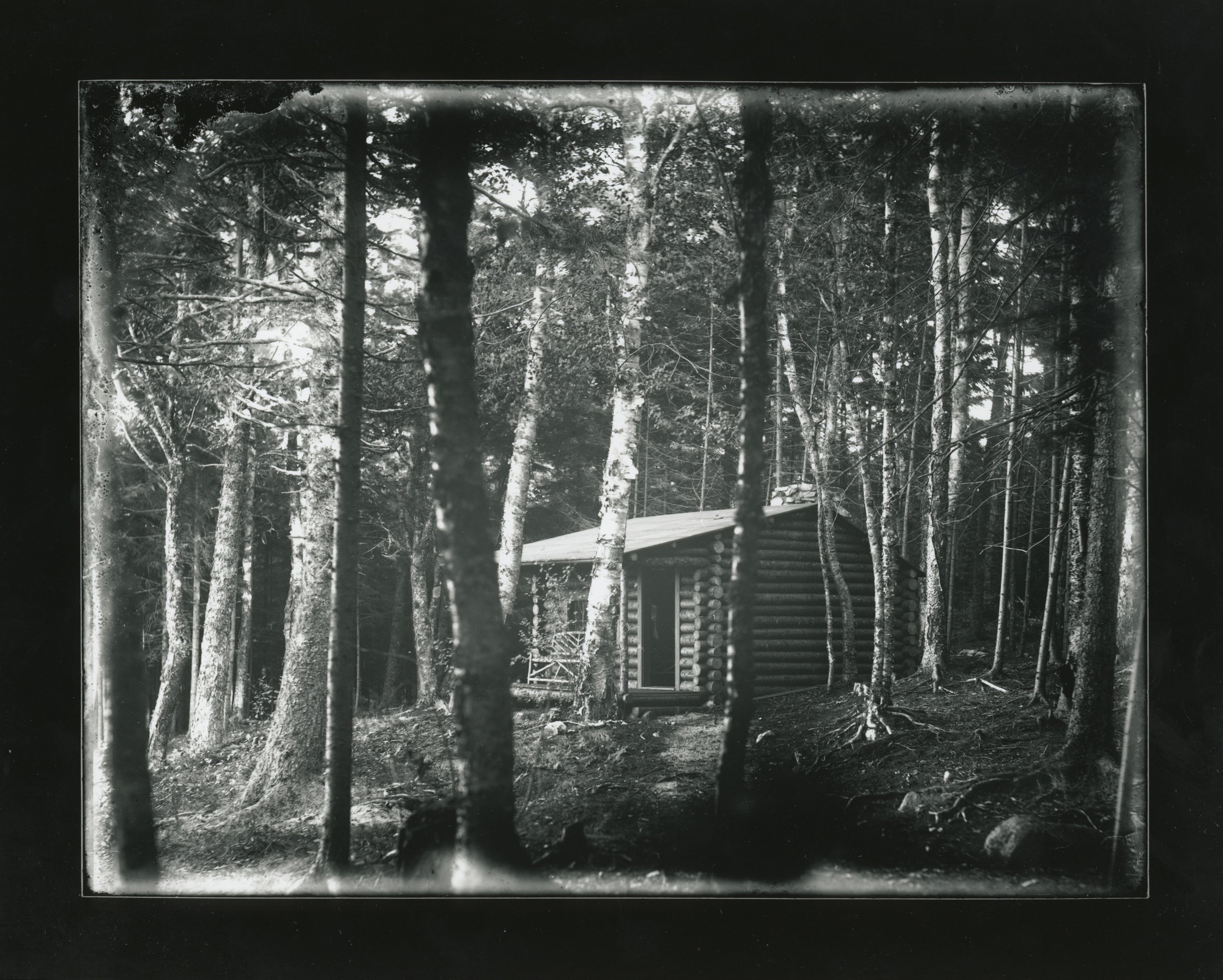 Log cabin surrounded by trees.