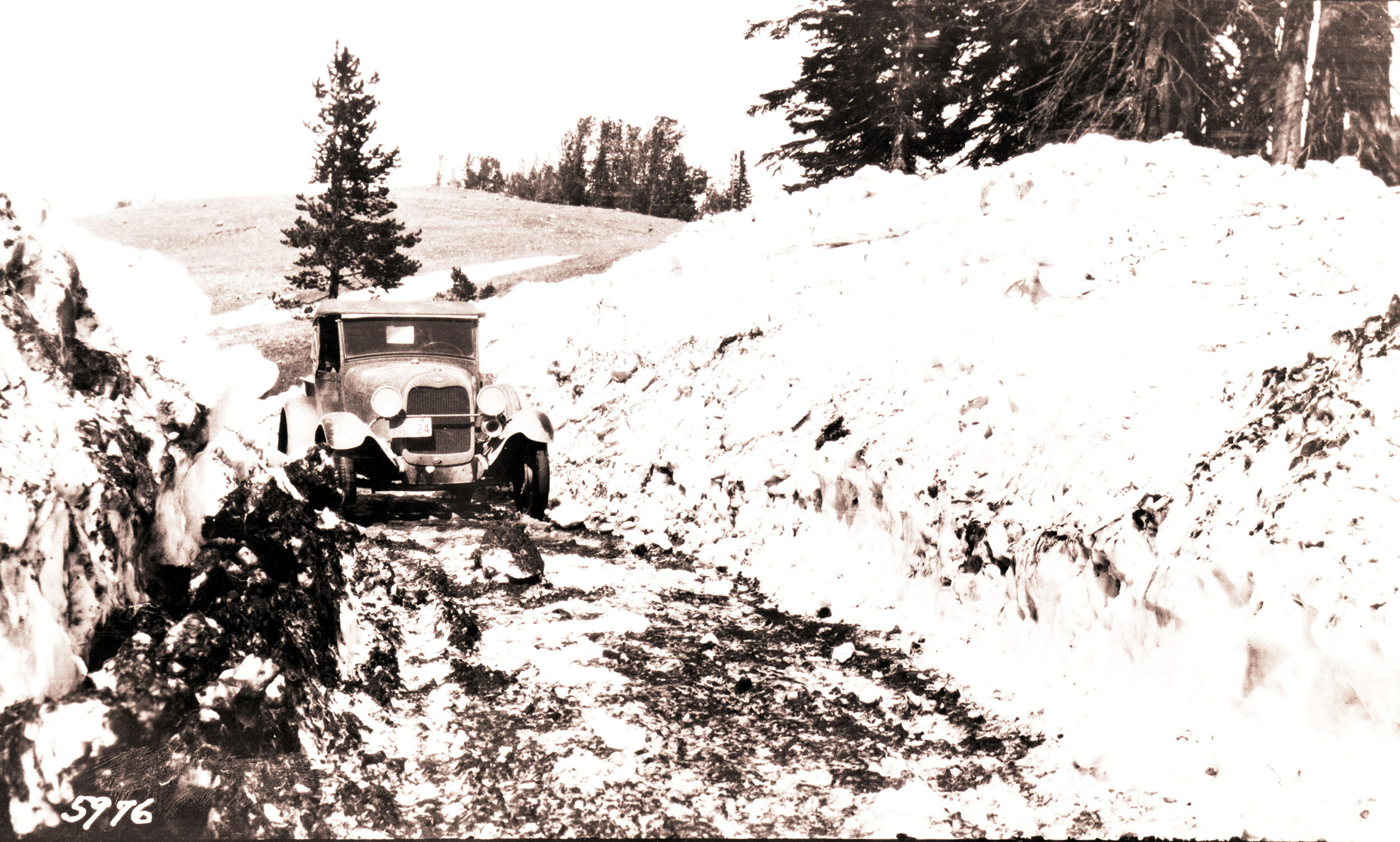 (NPS vehicle going through two large piles of snow on opening day)