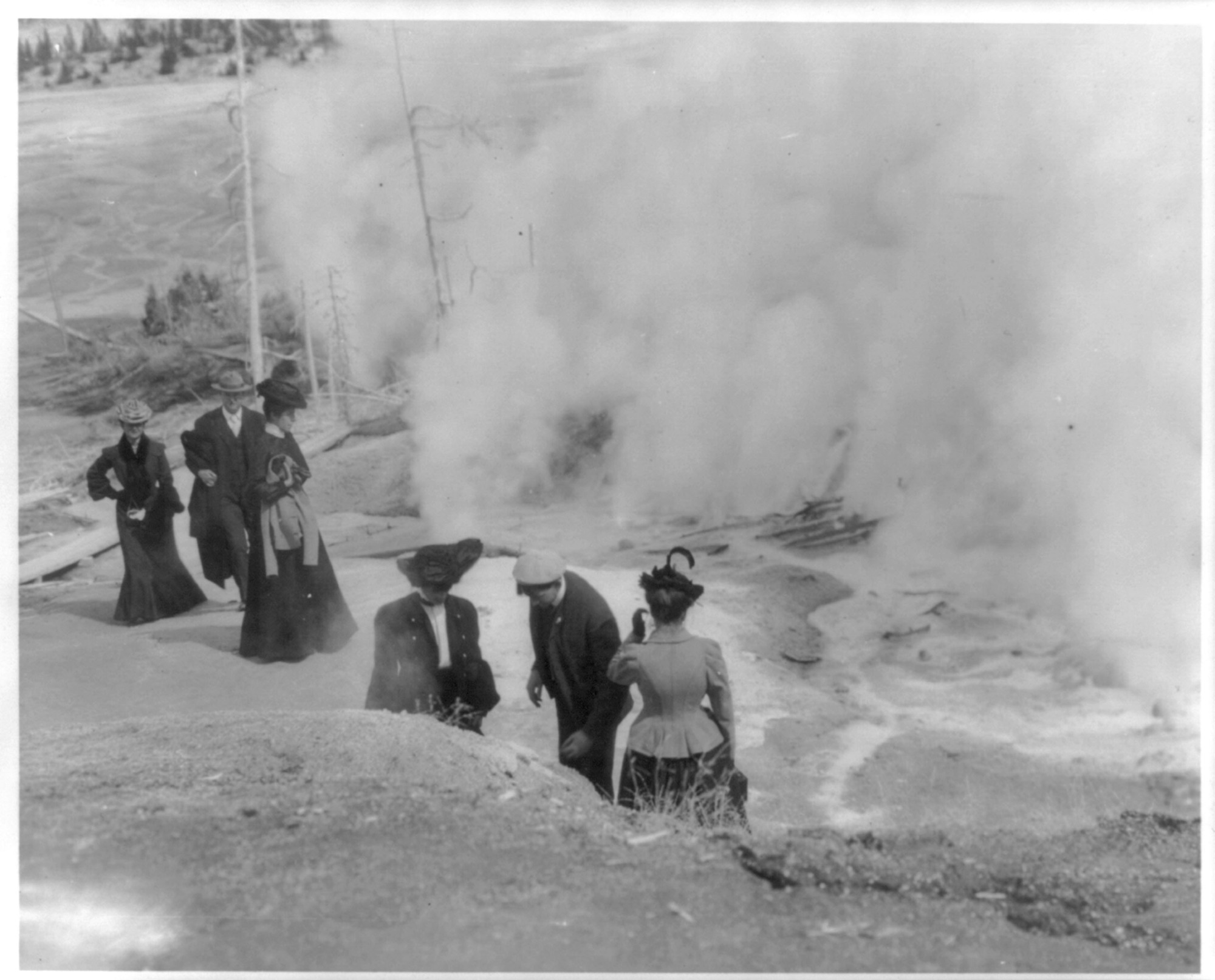 (Tourists in Yellowstone Park viewing steaming geysers)