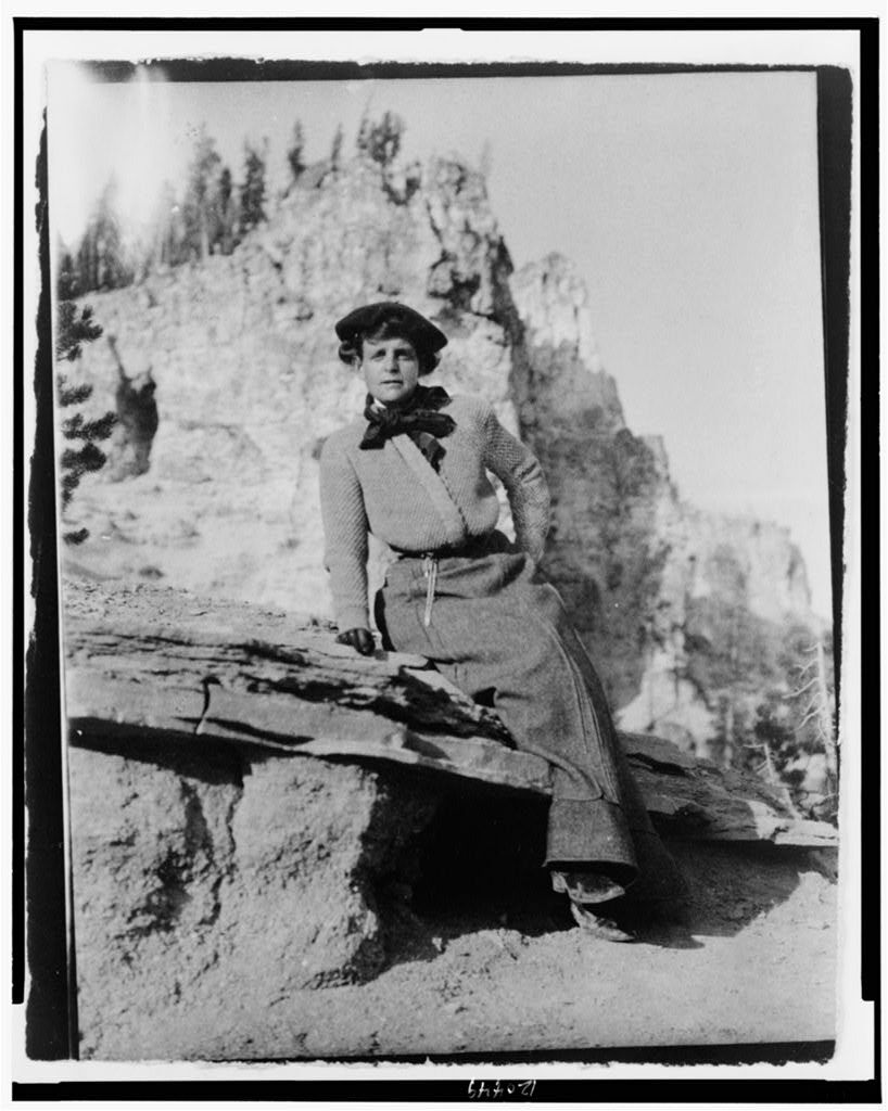 (Frances Benjamin Johnston, full-length portrait, seated on rock in Yellowstone National Park, facing front)