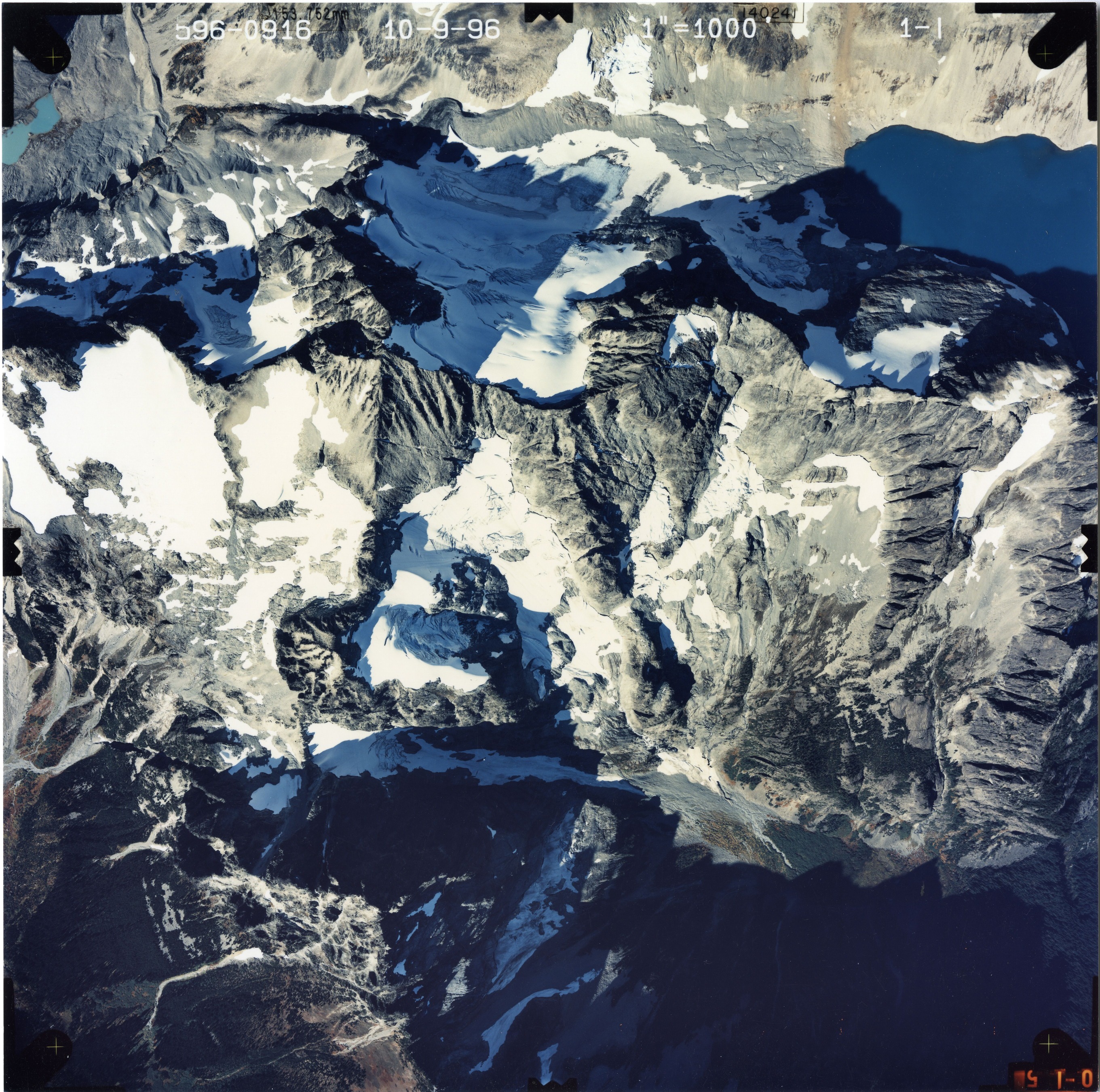 Color aerial photograph of glacier and snowfields on mountain peak.