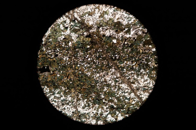 Circular microscopic image of rock structure.