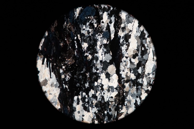 Circular microscopic image of rock structure.