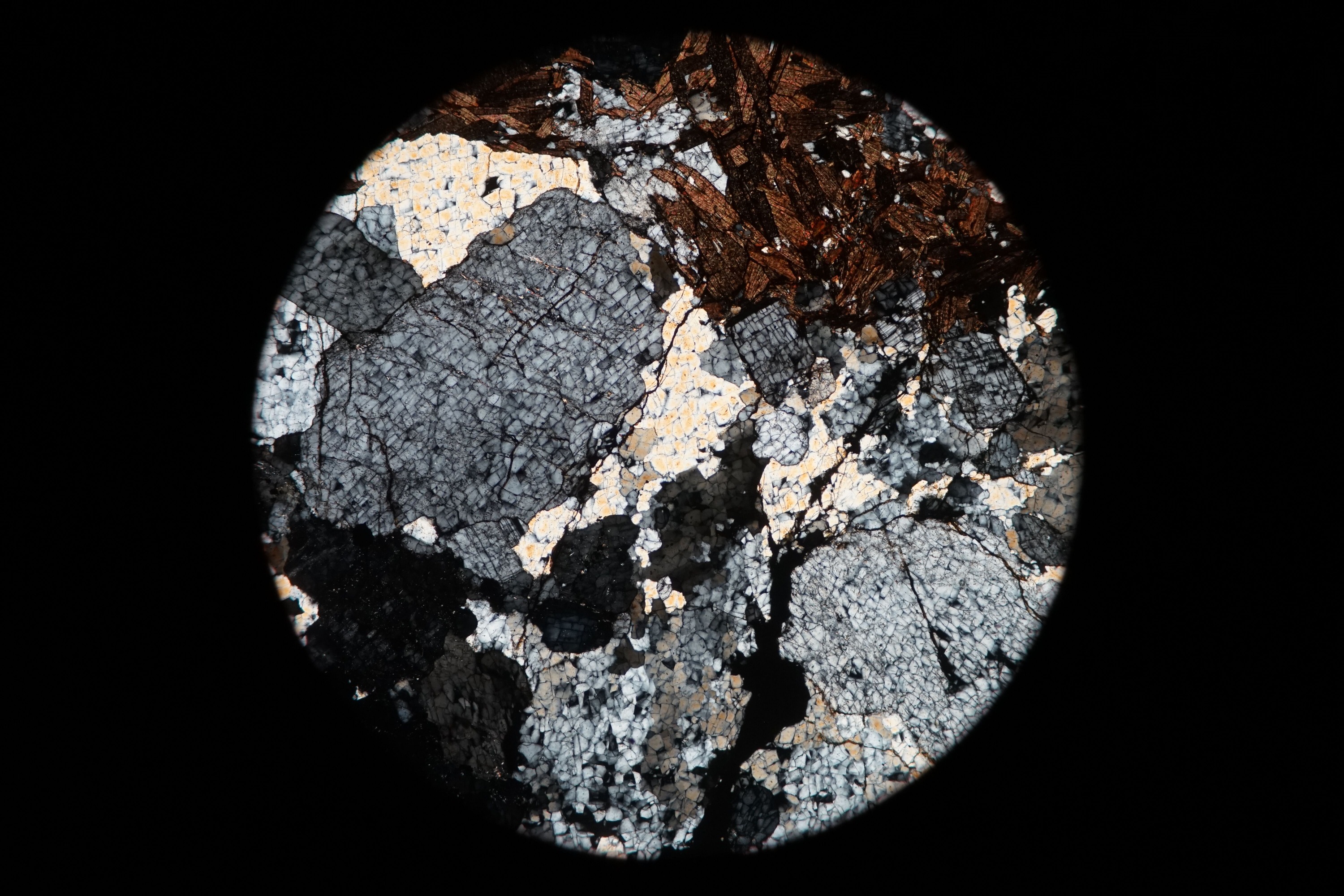 Circular microscopic image of rock structure.