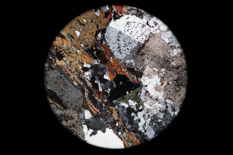 Circular microscopic image of rock structure.