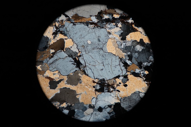 Circular microscopic image of rock structure.
