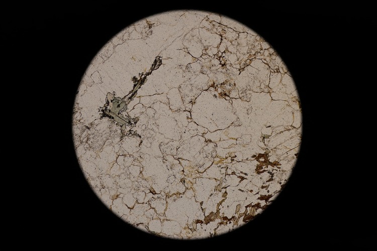 Circular microscopic image of rock structure.