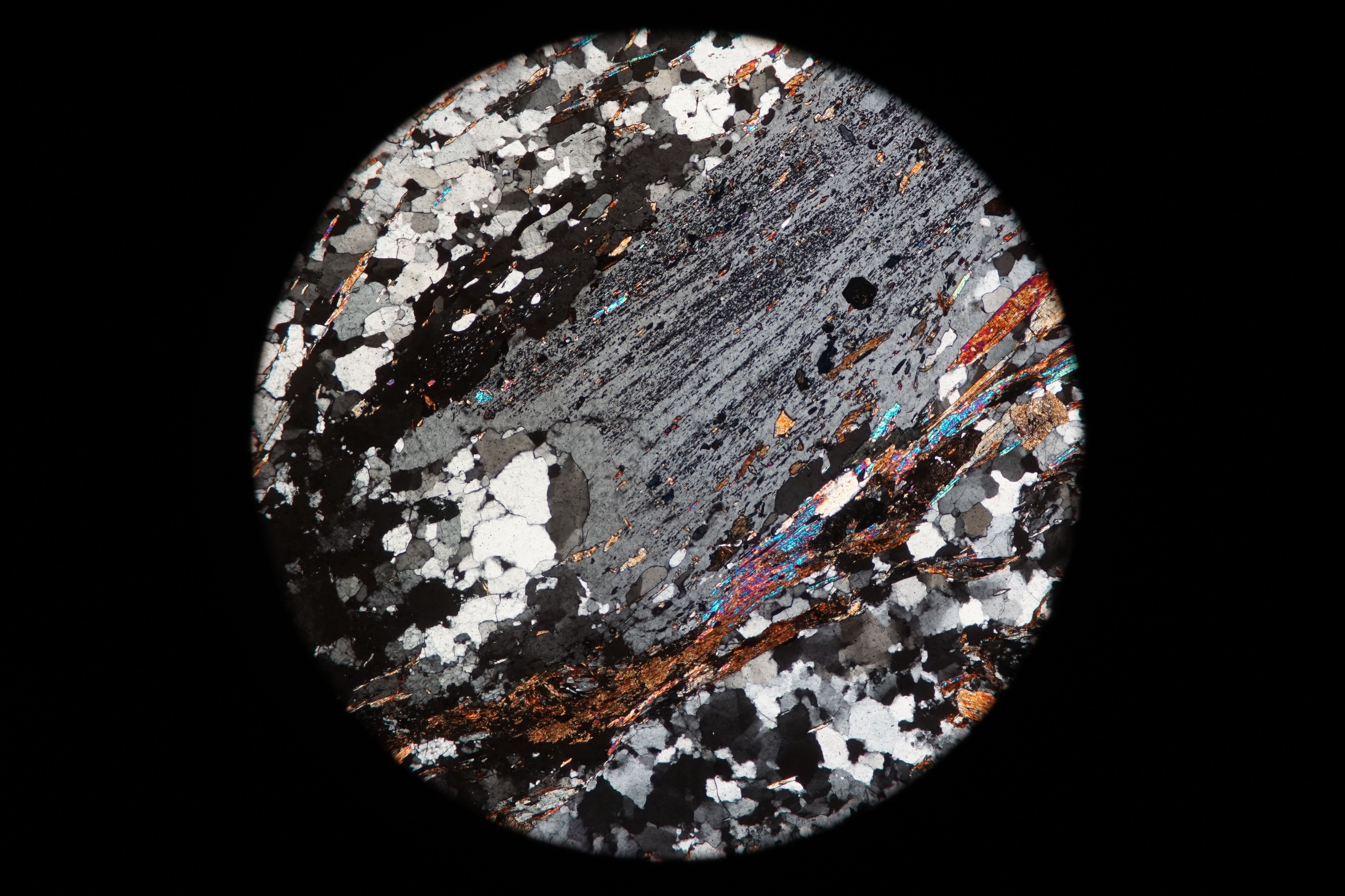 Circular microscopic image of rock structure.