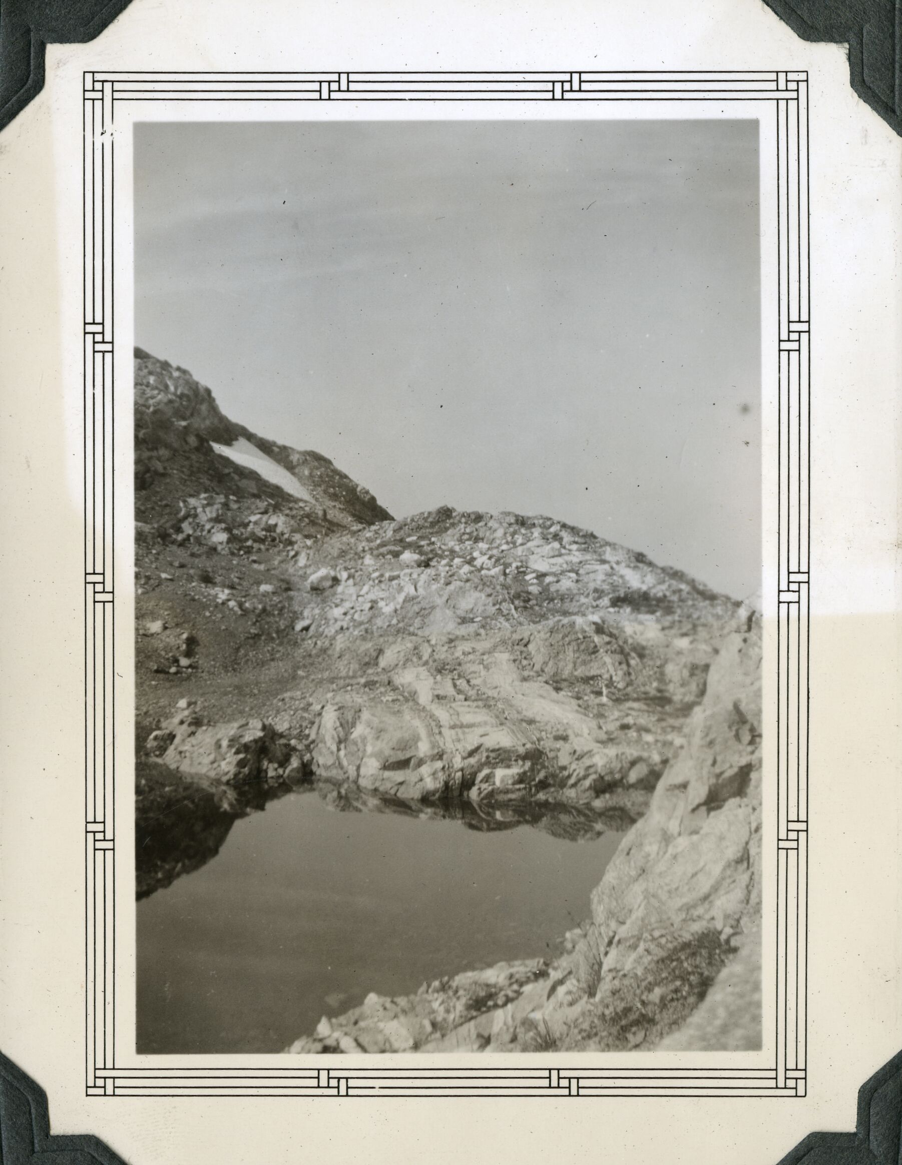 Small body of water in rocky landscape.