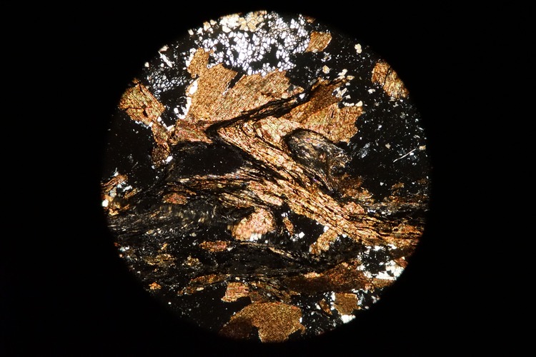 Circular microscopic image of rock structure.
