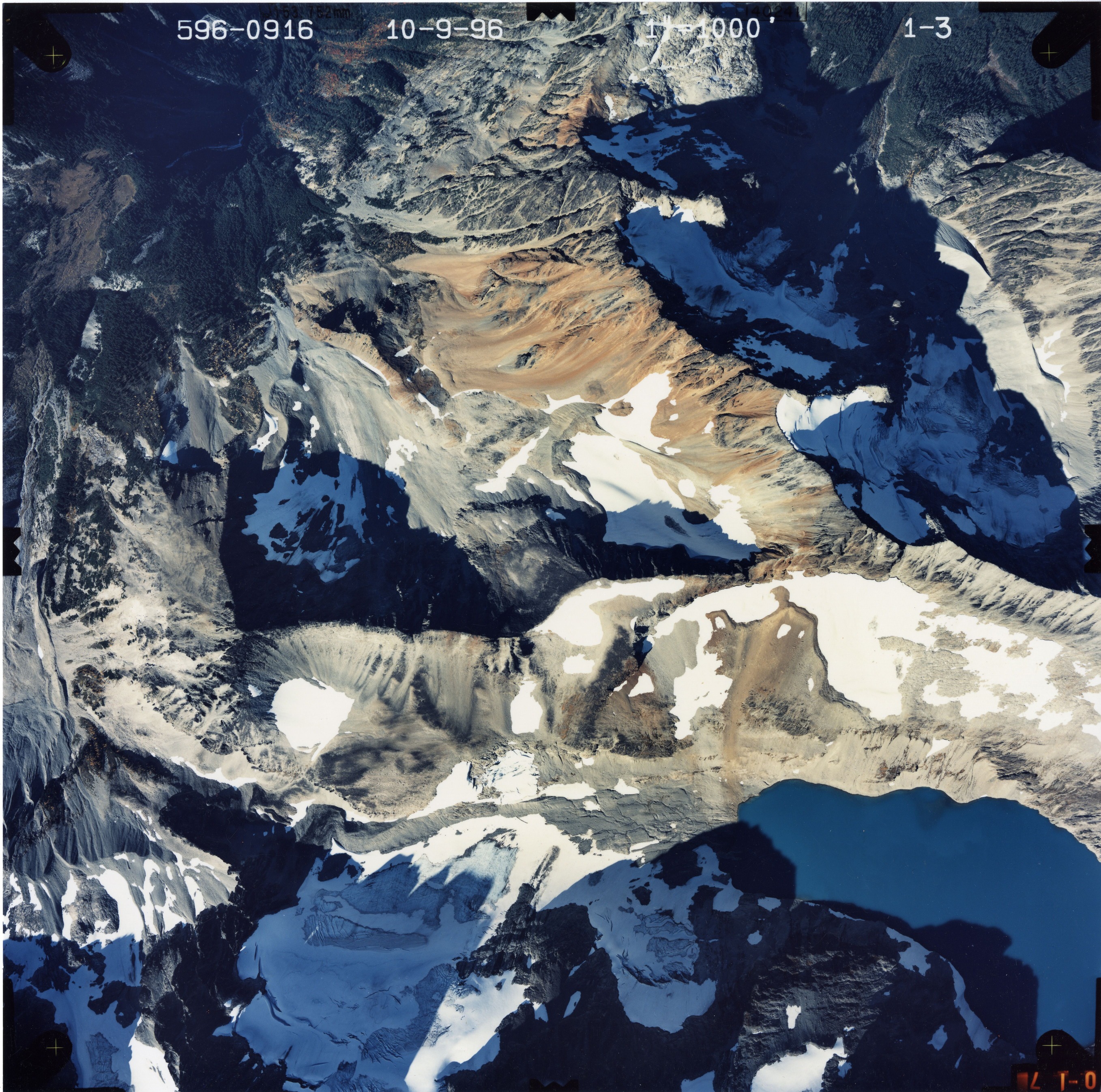Color aerial photograph of glacier and snowfields on mountain peak.