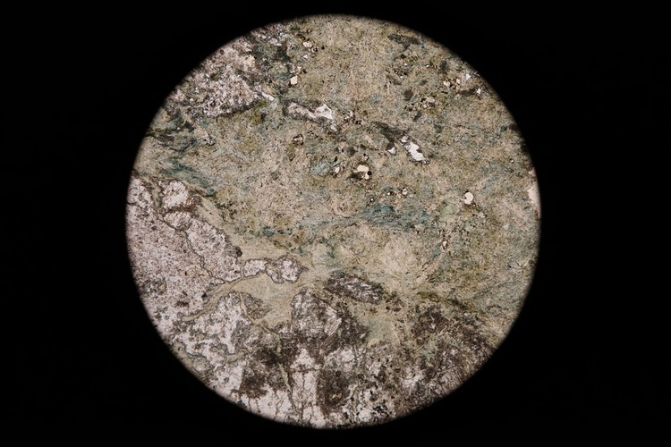 Circular microscopic image of rock structure.