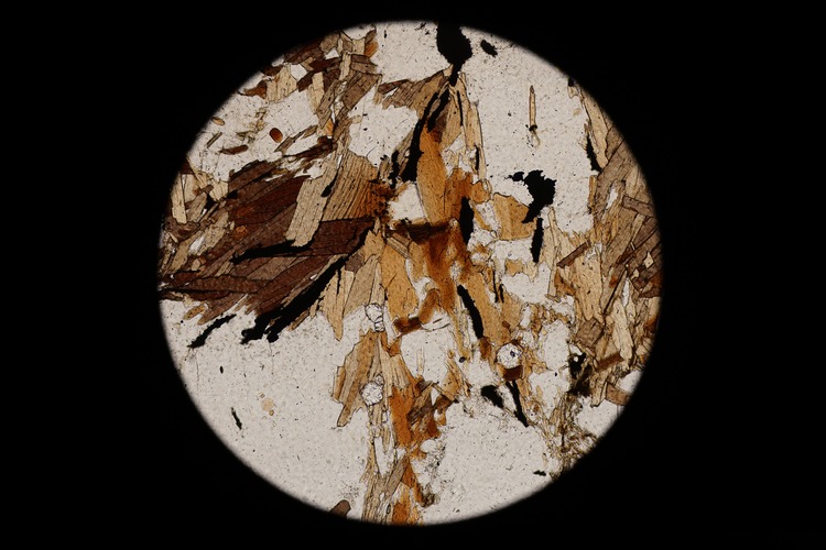 Circular microscopic image of rock structure.