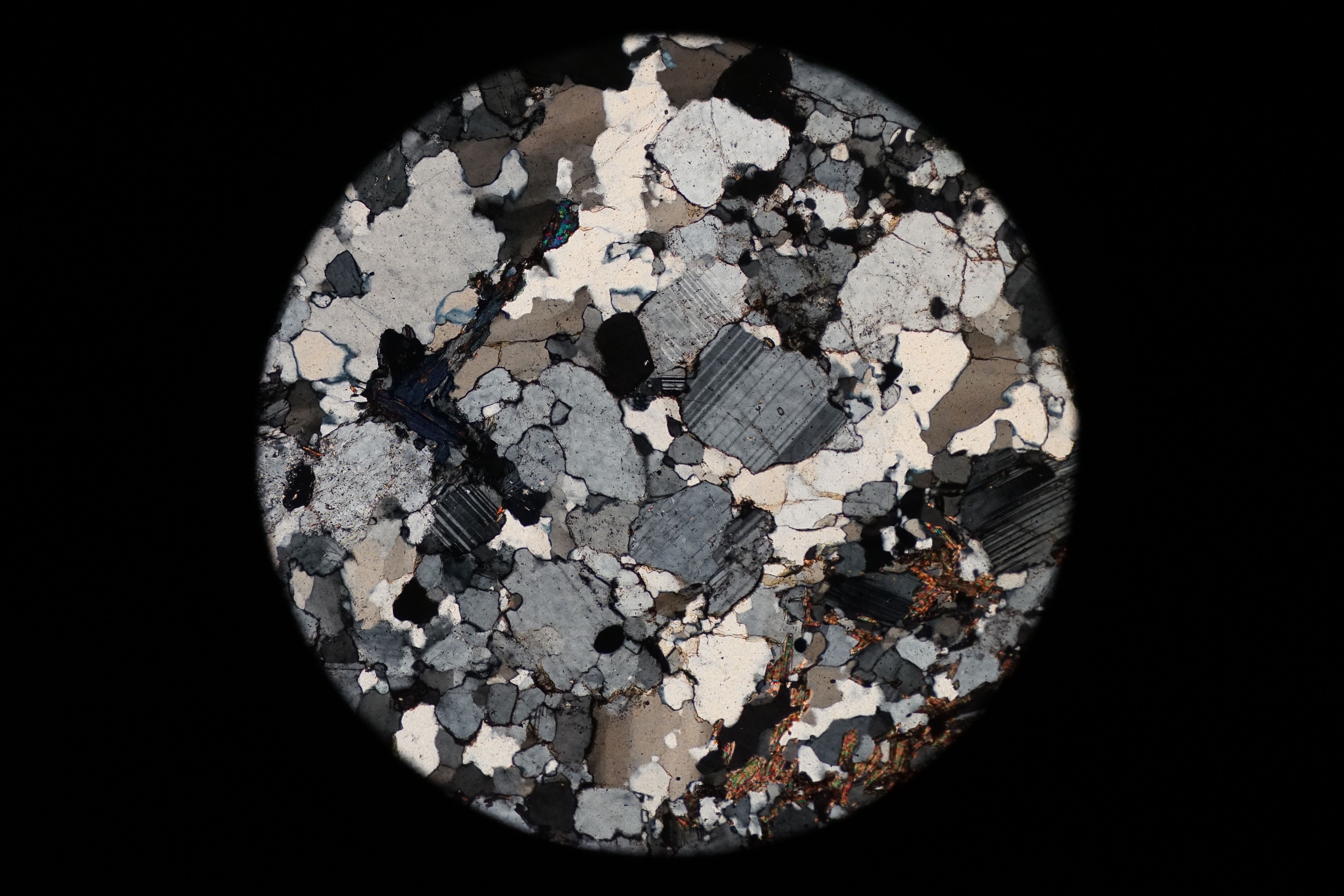 Circular microscopic image of rock structure.