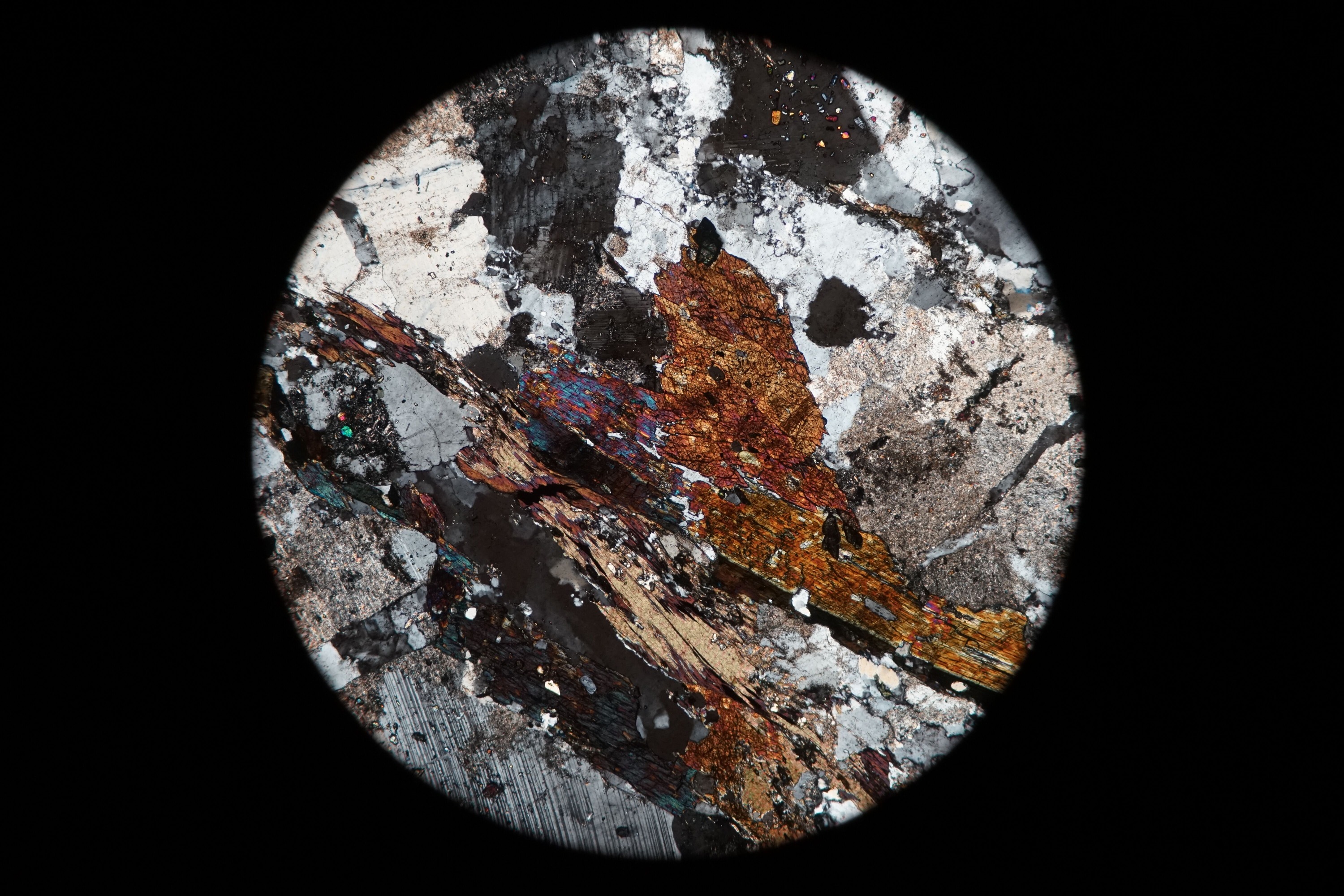 Circular microscopic image of rock structure.