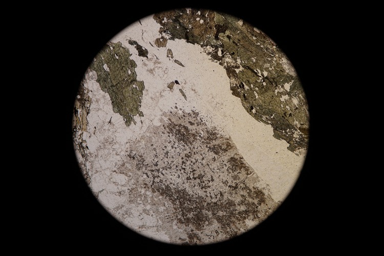 Circular microscopic image of rock structure.