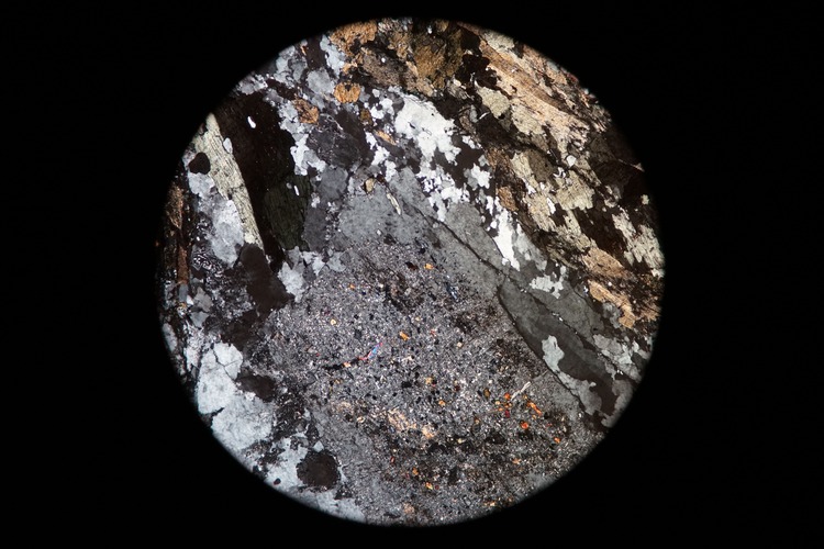 Circular microscopic image of rock structure.