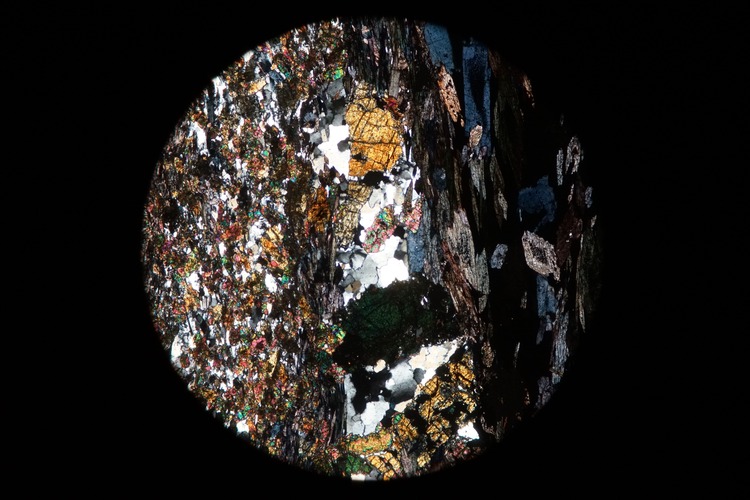 Circular microscopic image of rock structure.