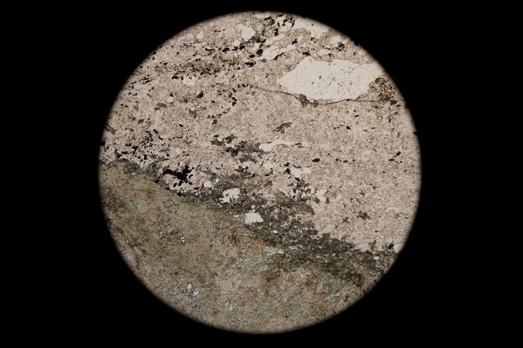 Circular microscopic image of rock structure.