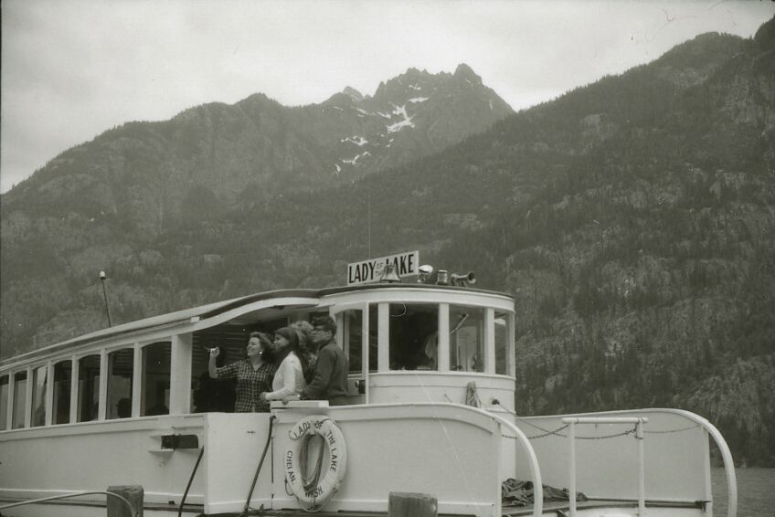 People boarding a boat on a lake.