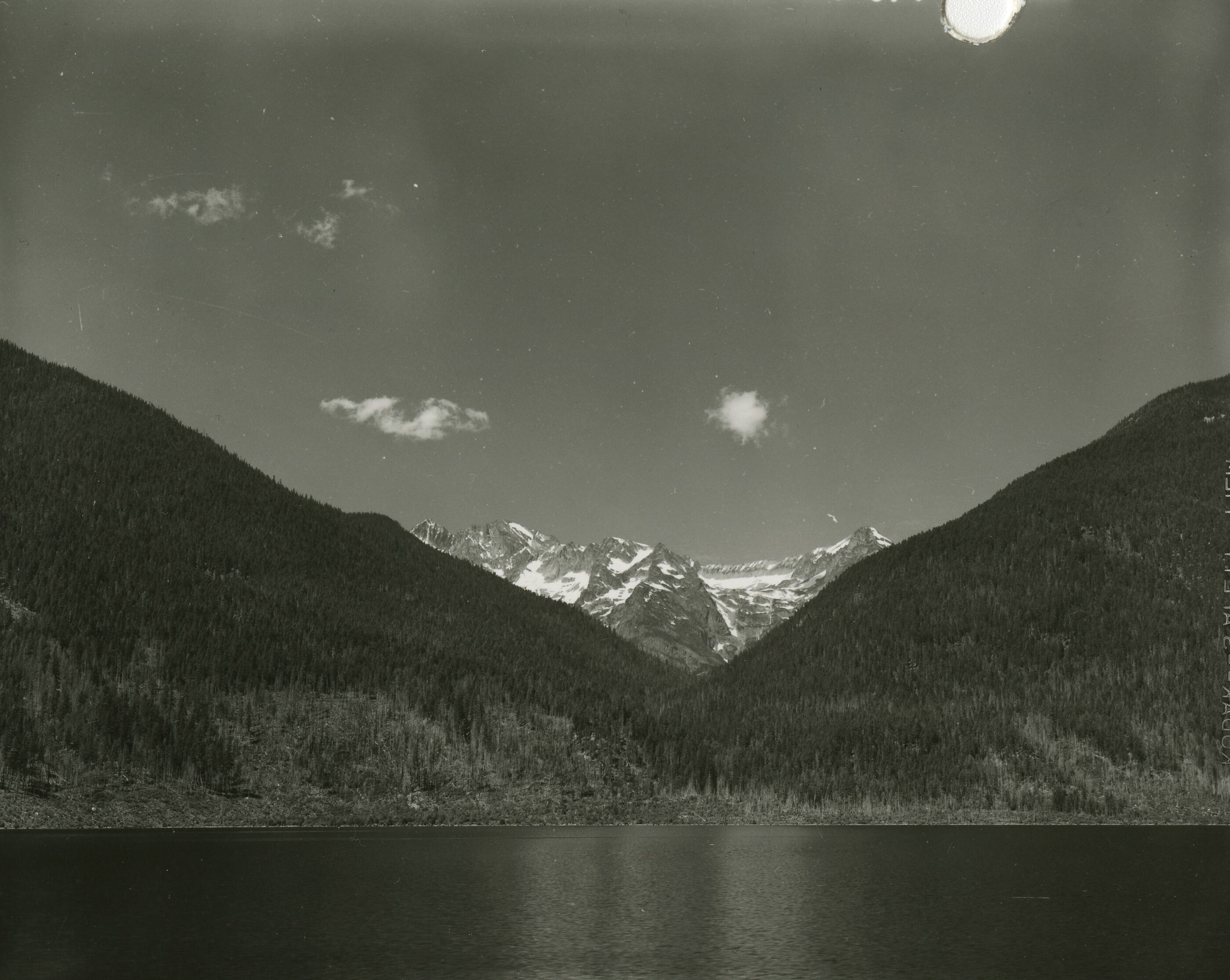 A lake with forested slopes in the background.
