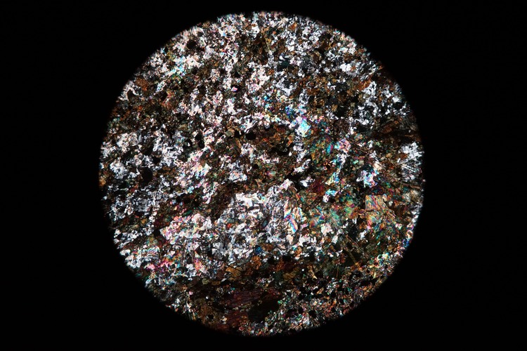 Circular microscopic image of rock structure.