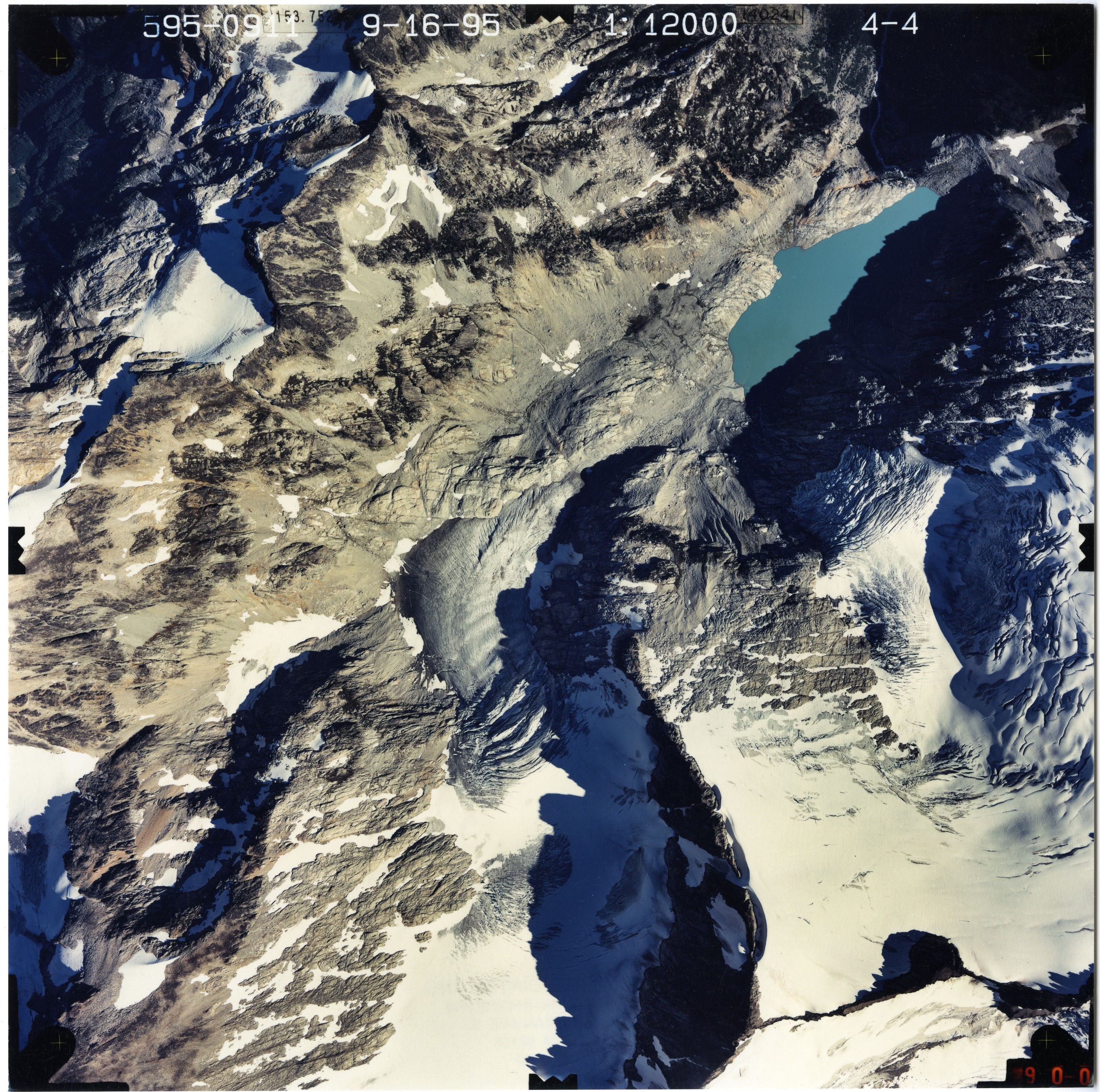 Color aerial photograph of glacier and snowfields on mountain peak.