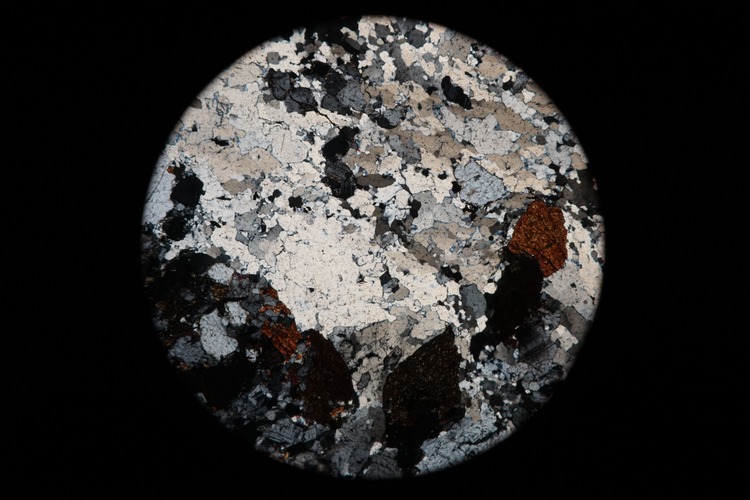 Circular microscopic image of rock structure.