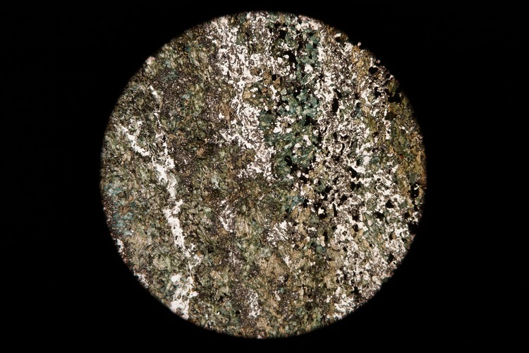 Circular microscopic image of rock structure.