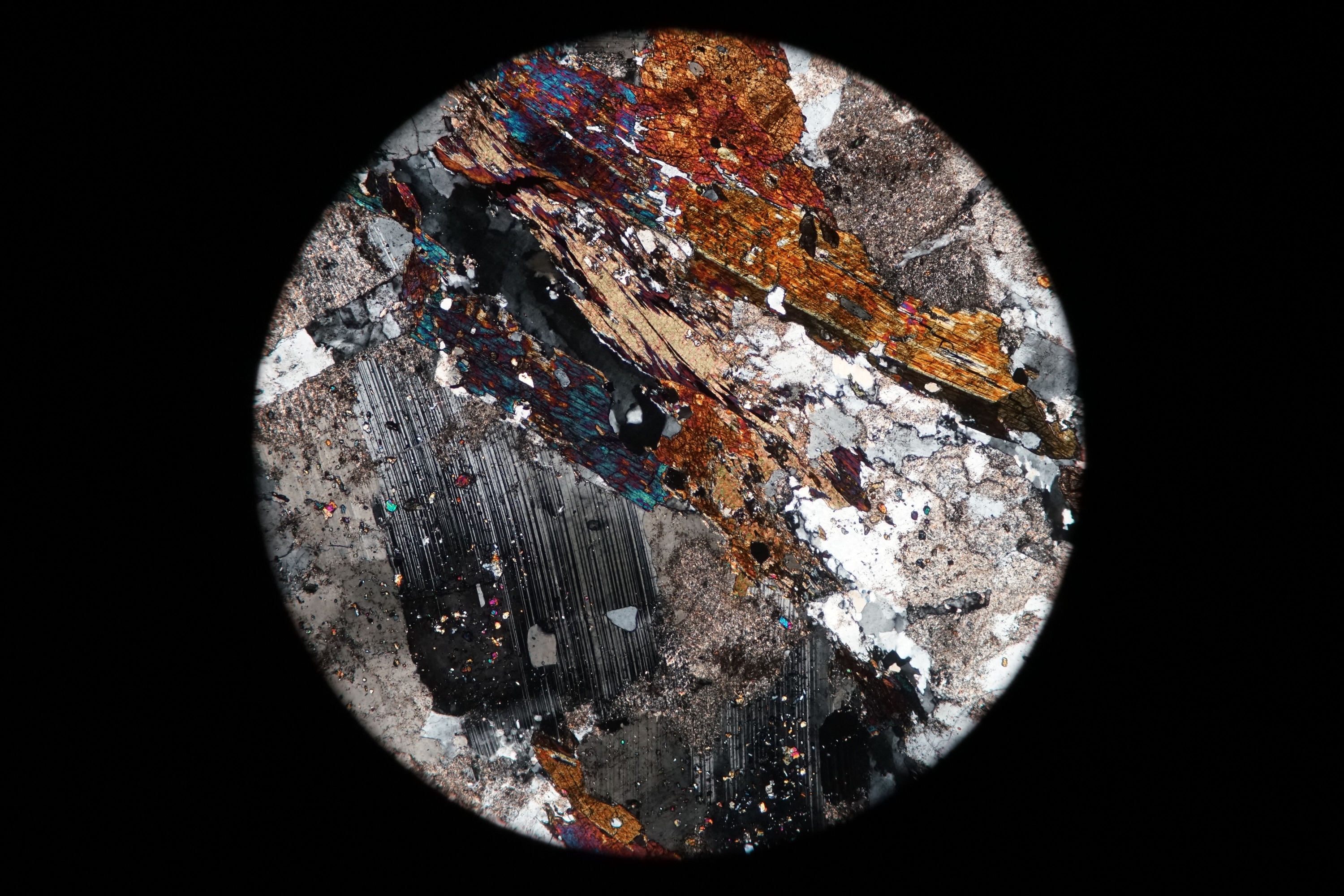 Circular microscopic image of rock structure.