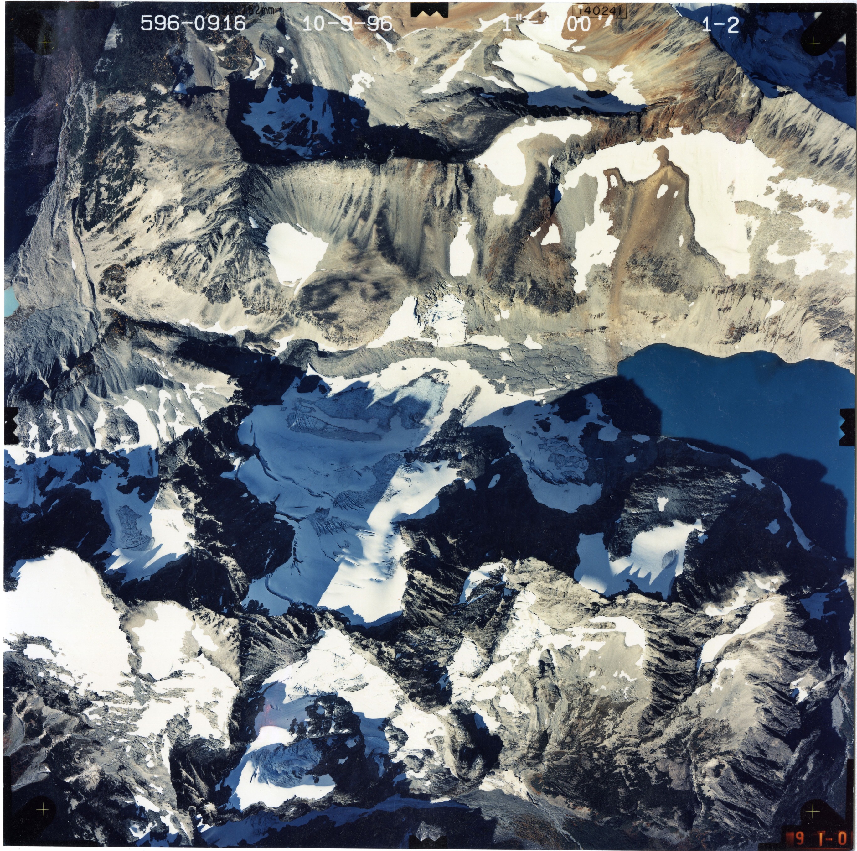 Color aerial photograph of glacier and snowfields on mountain peak.
