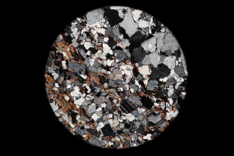 Circular microscopic image of rock structure.
