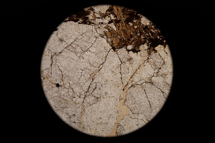 Circular microscopic image of rock structure.