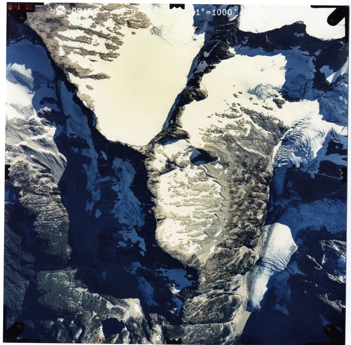 Color aerial photograph of glacier and snowfields on mountain peak.