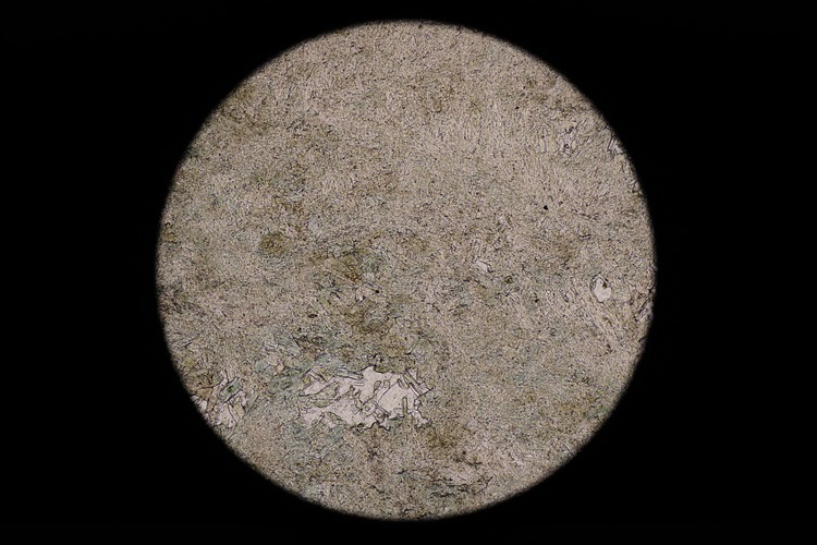 Circular microscopic image of rock structure.