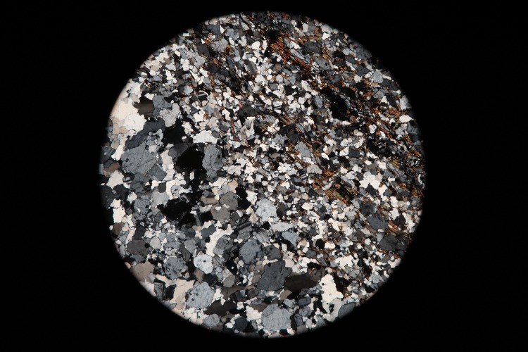 Circular microscopic image of rock structure.