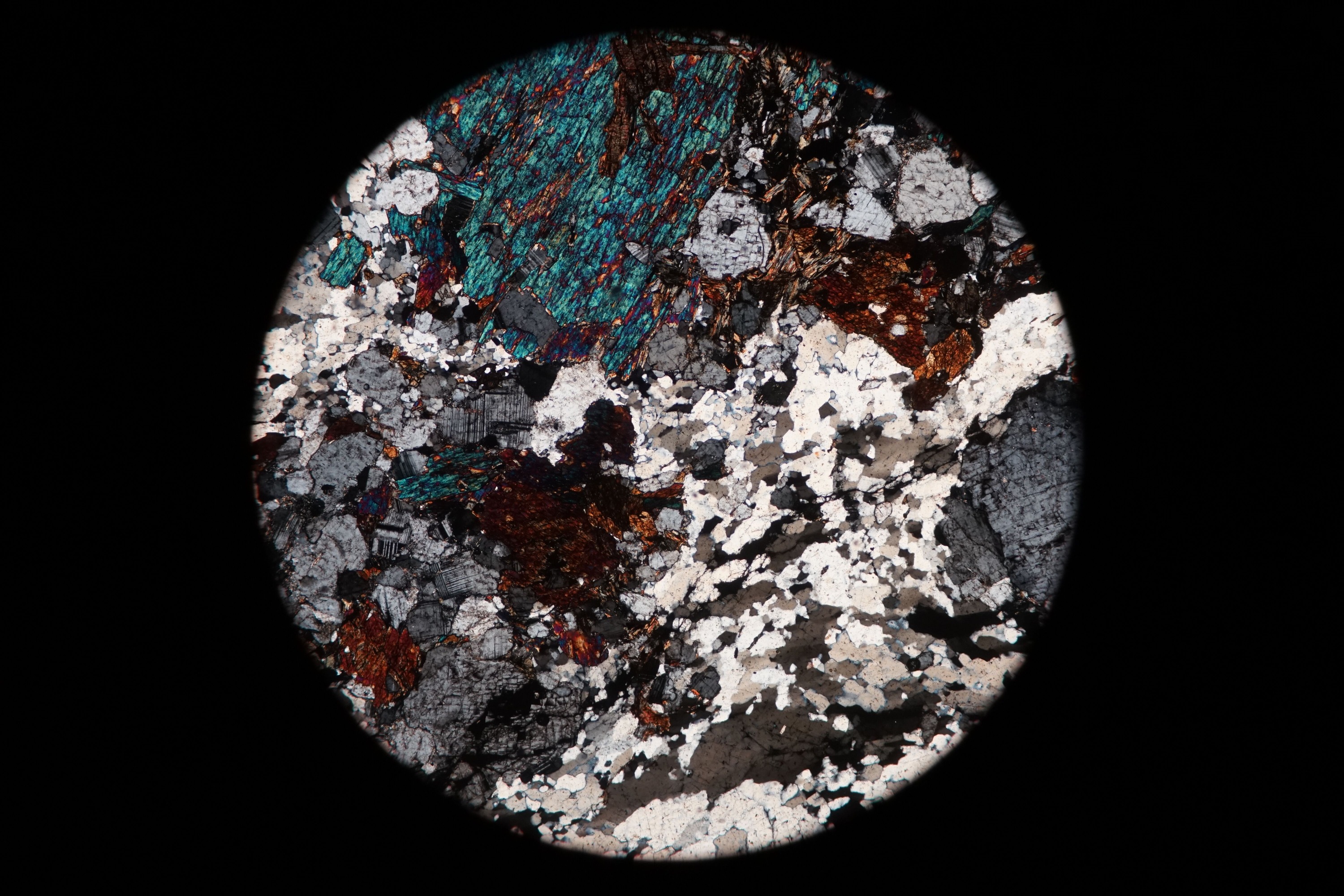 Circular microscopic image of rock structure.