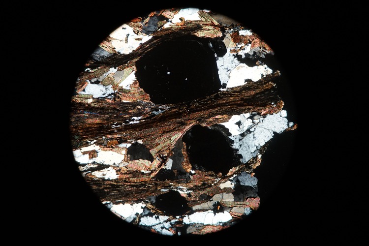Circular microscopic image of rock structure.