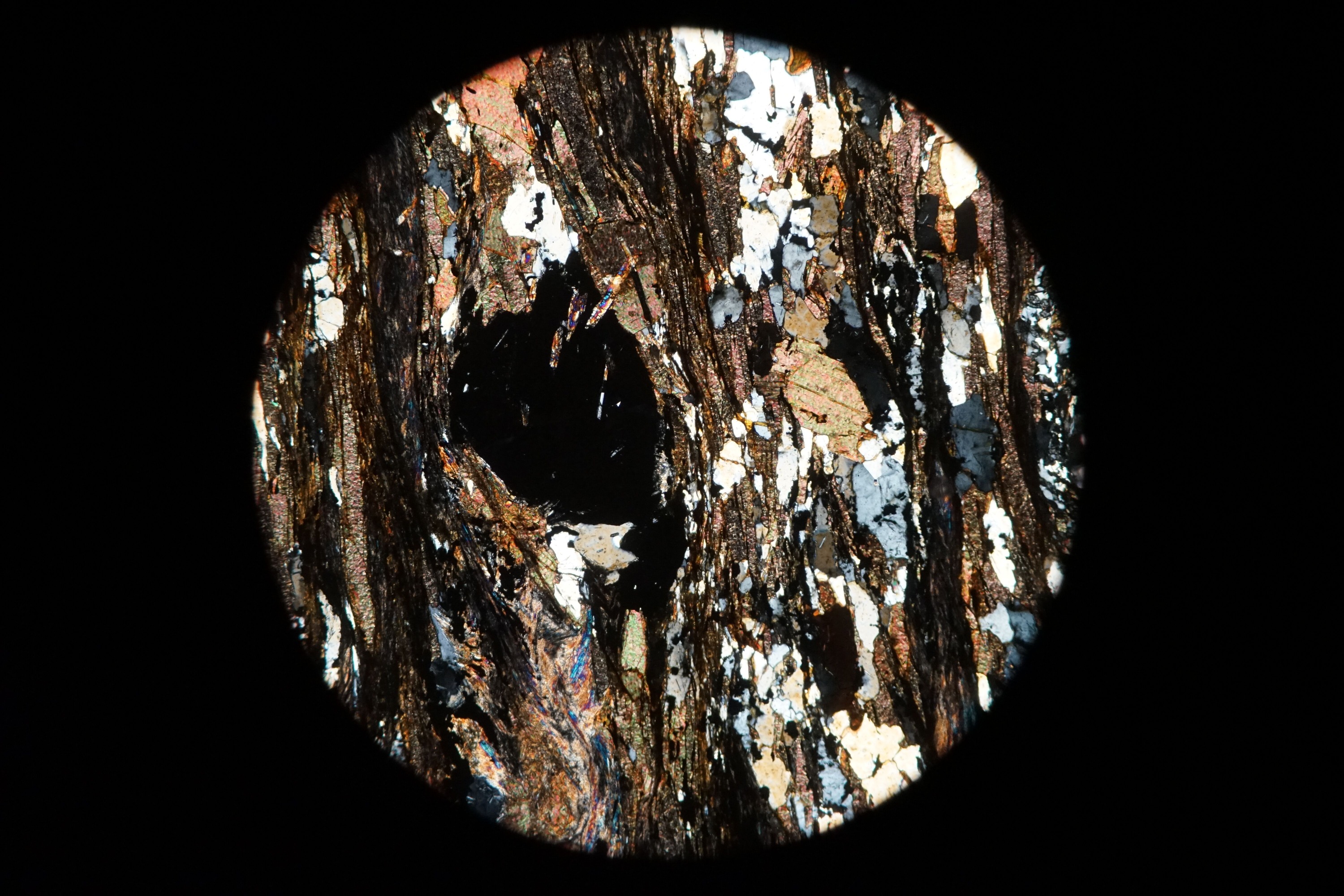 Circular microscopic image of rock structure.