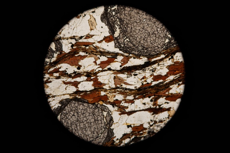 Circular microscopic image of rock structure.