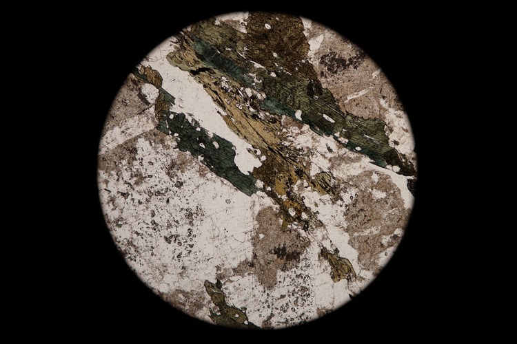Circular microscopic image of rock structure.