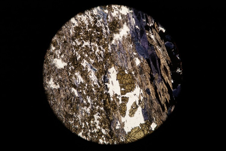 Circular microscopic image of rock structure.