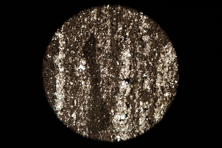 Circular microscopic image of rock structure.