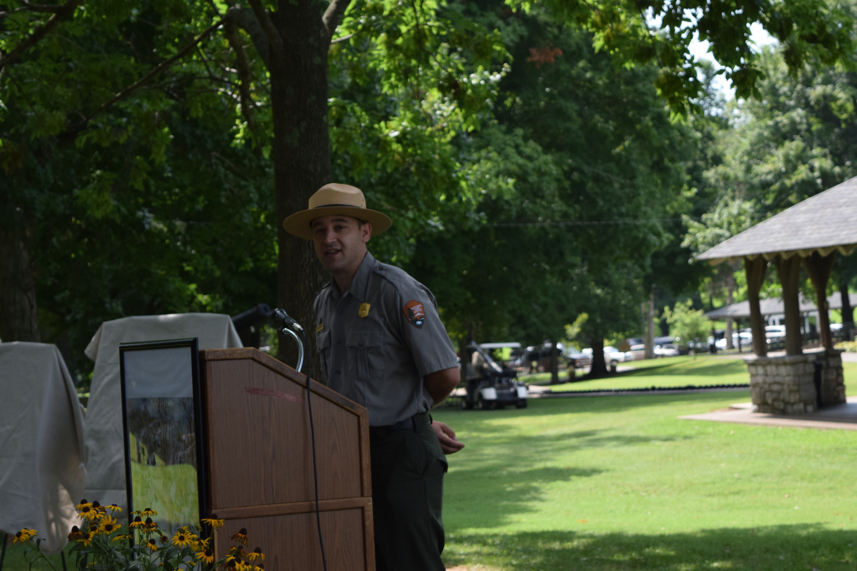A man in a hat standing at a podium.