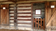 A wooden door in a log cabin.