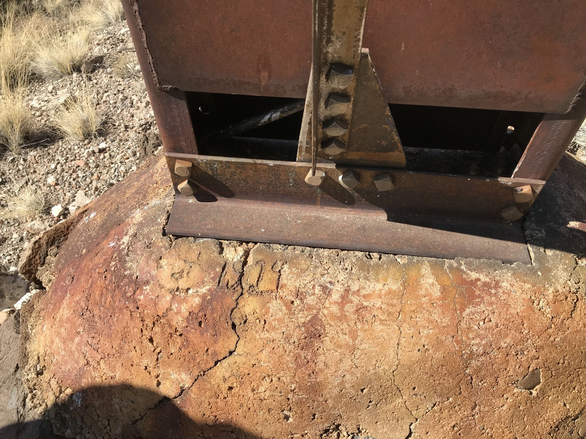 A rusty piece of metal sitting on top of a rock.